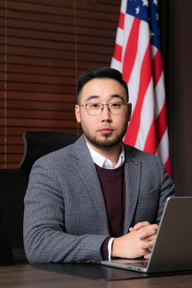 Batkhuu Byambajargal seated at a desk in a grey blazer