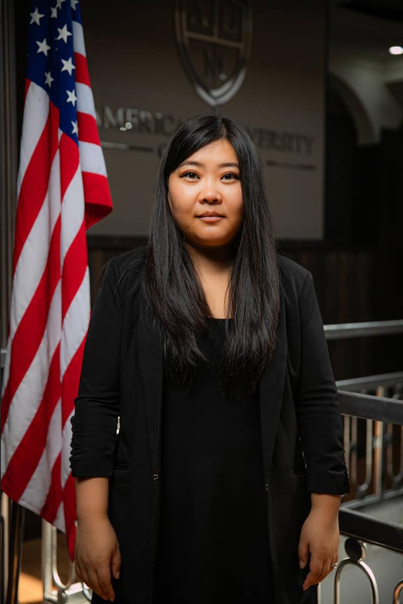 Mrs. Bayaraa Zorigt standing beside the American flag at AUM