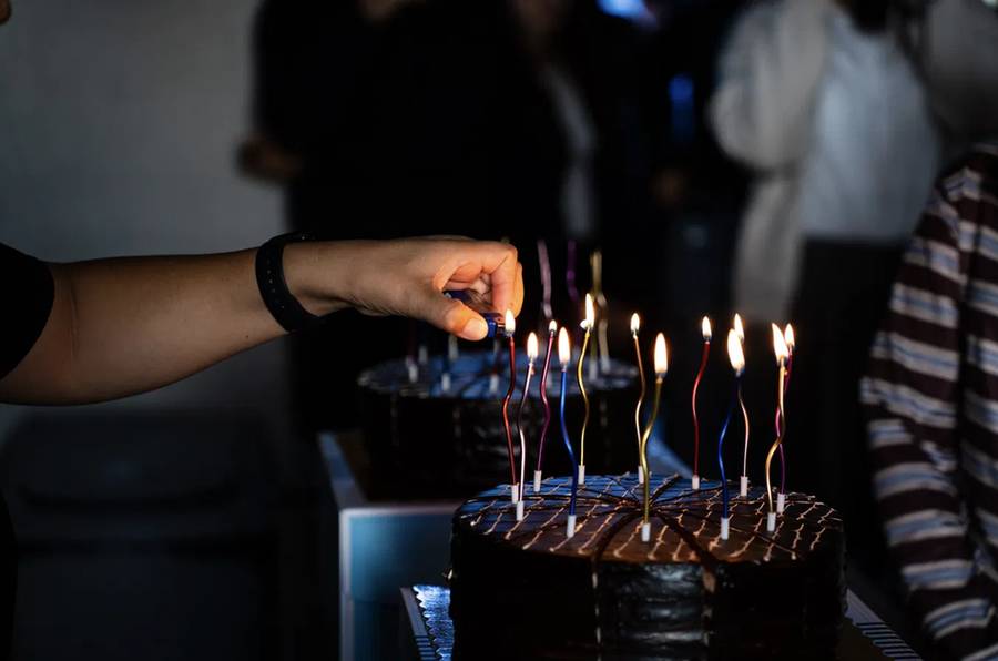Candles being lit on a chocolate cake