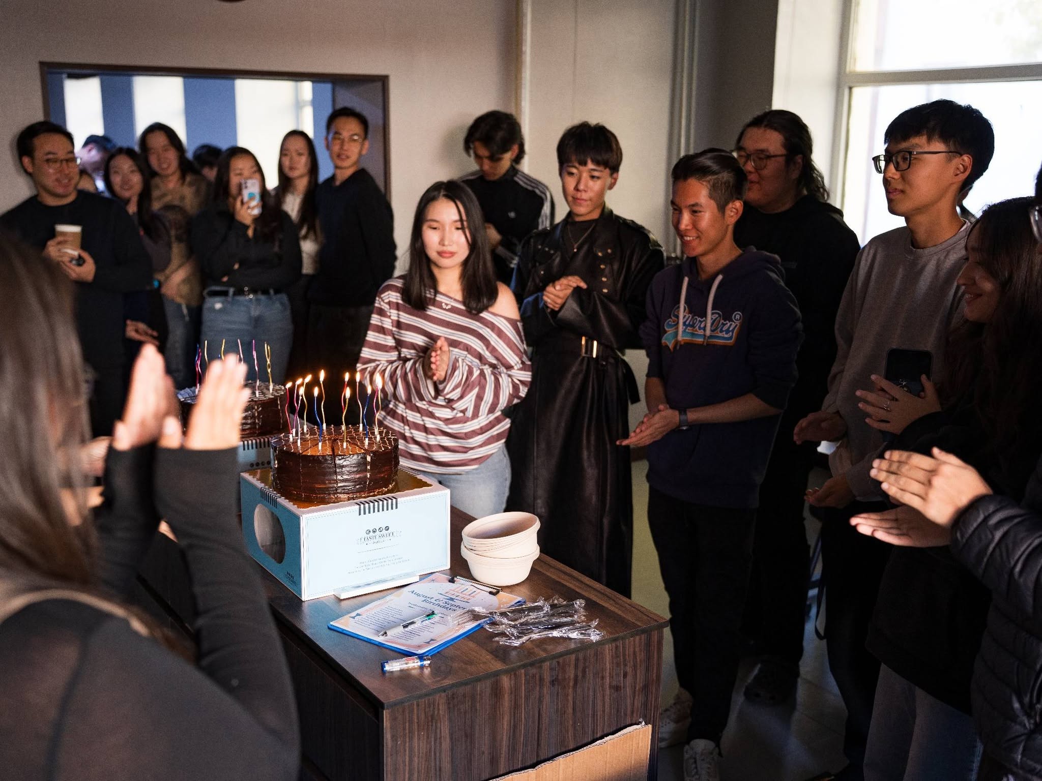 Students gathered around birthday cakes at AUM